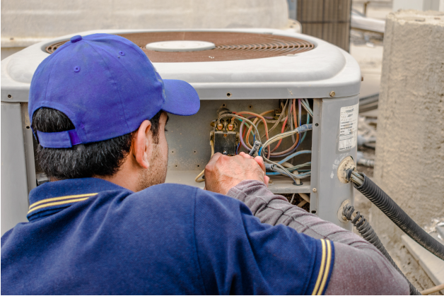 Technician in front of open AC unit | Pro Comfort Heating & Cooling